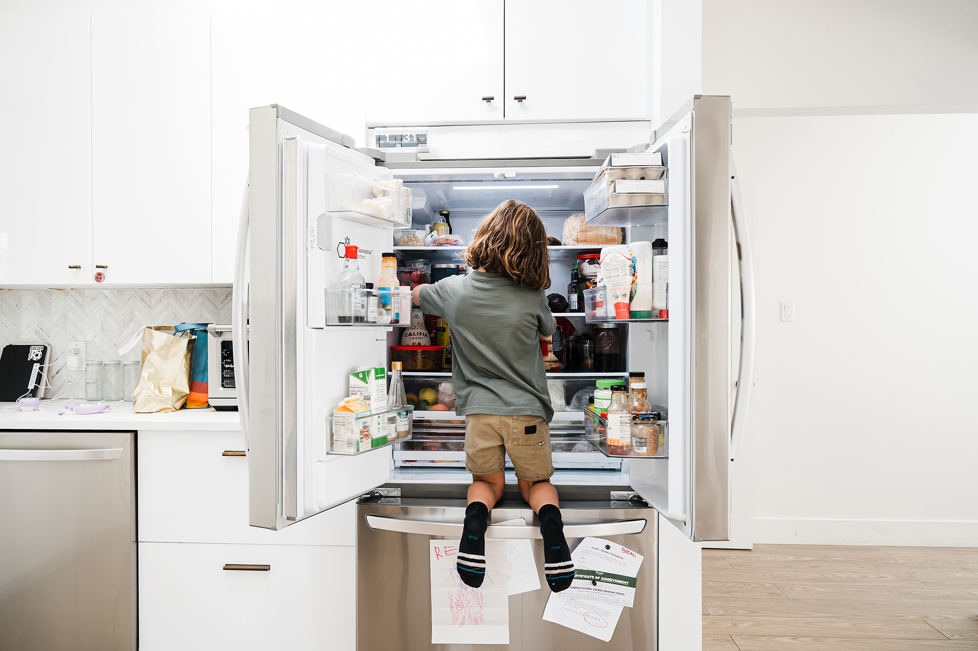 Child climbing in fridge during an at-home family session