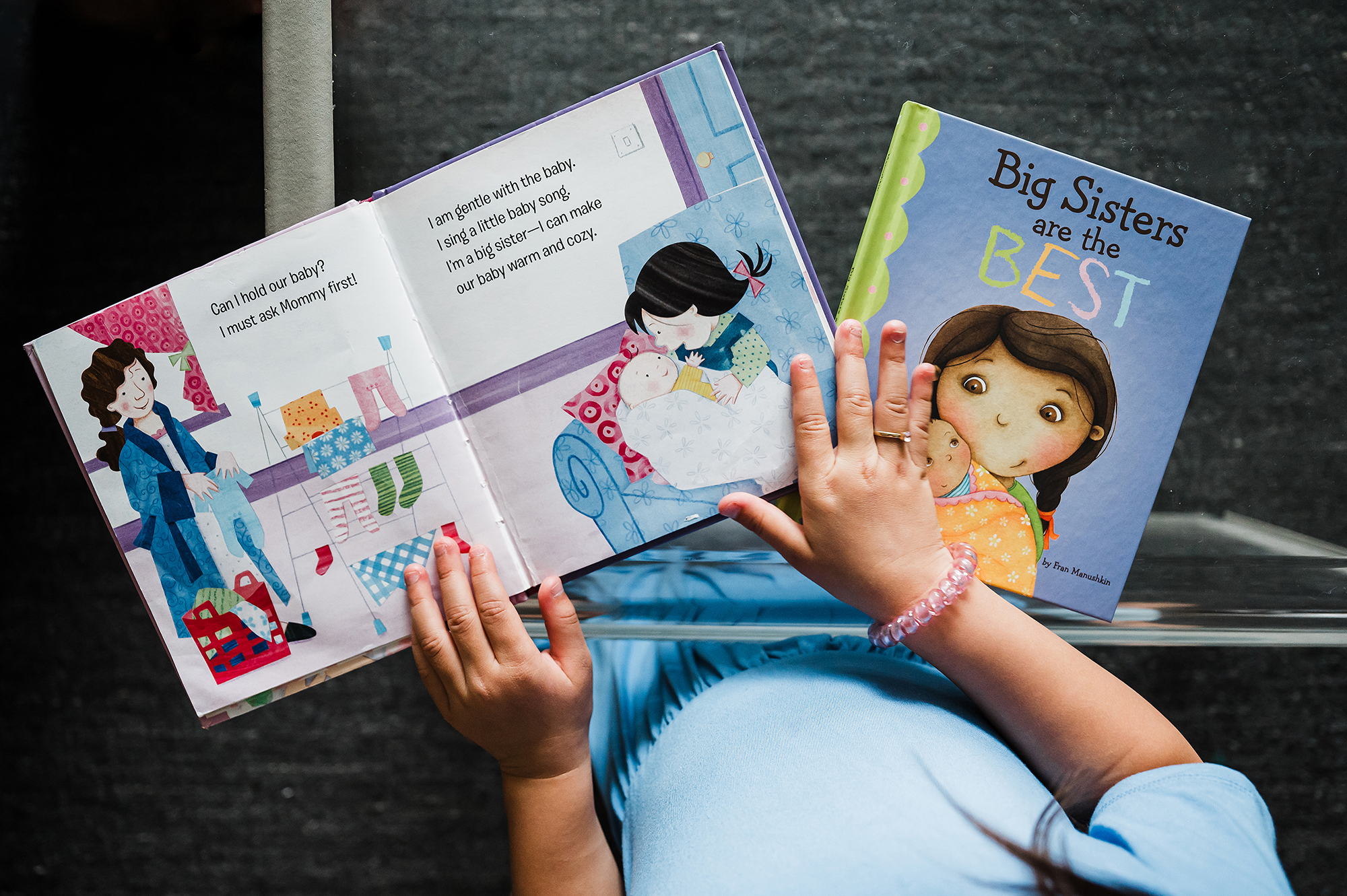 Child holding “Big Sisters Are the Best” book.